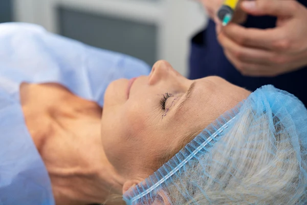 Médico evaluando el tabique nasal de una paciente durante una valoración estética.