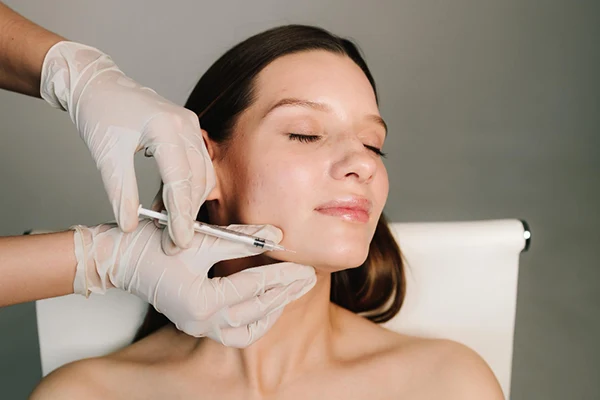 Médico evaluando el tabique nasal de una paciente durante una valoración estética.