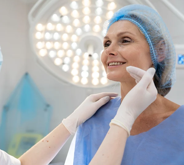 Médico examinando el interior de la nariz de una paciente con un espéculo nasal durante una valoración clínica.